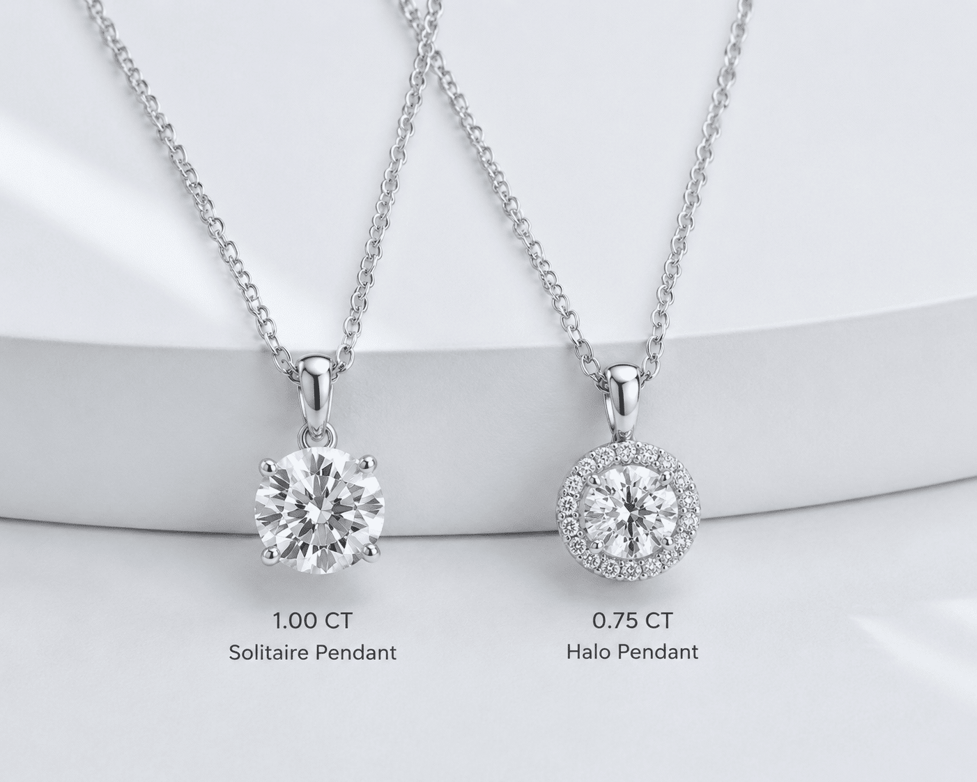 two necklaces side by side — a solitaire pendant with a 1-carat round stone and a halo pendant with a 0.75-carat center stone, both on simple chains