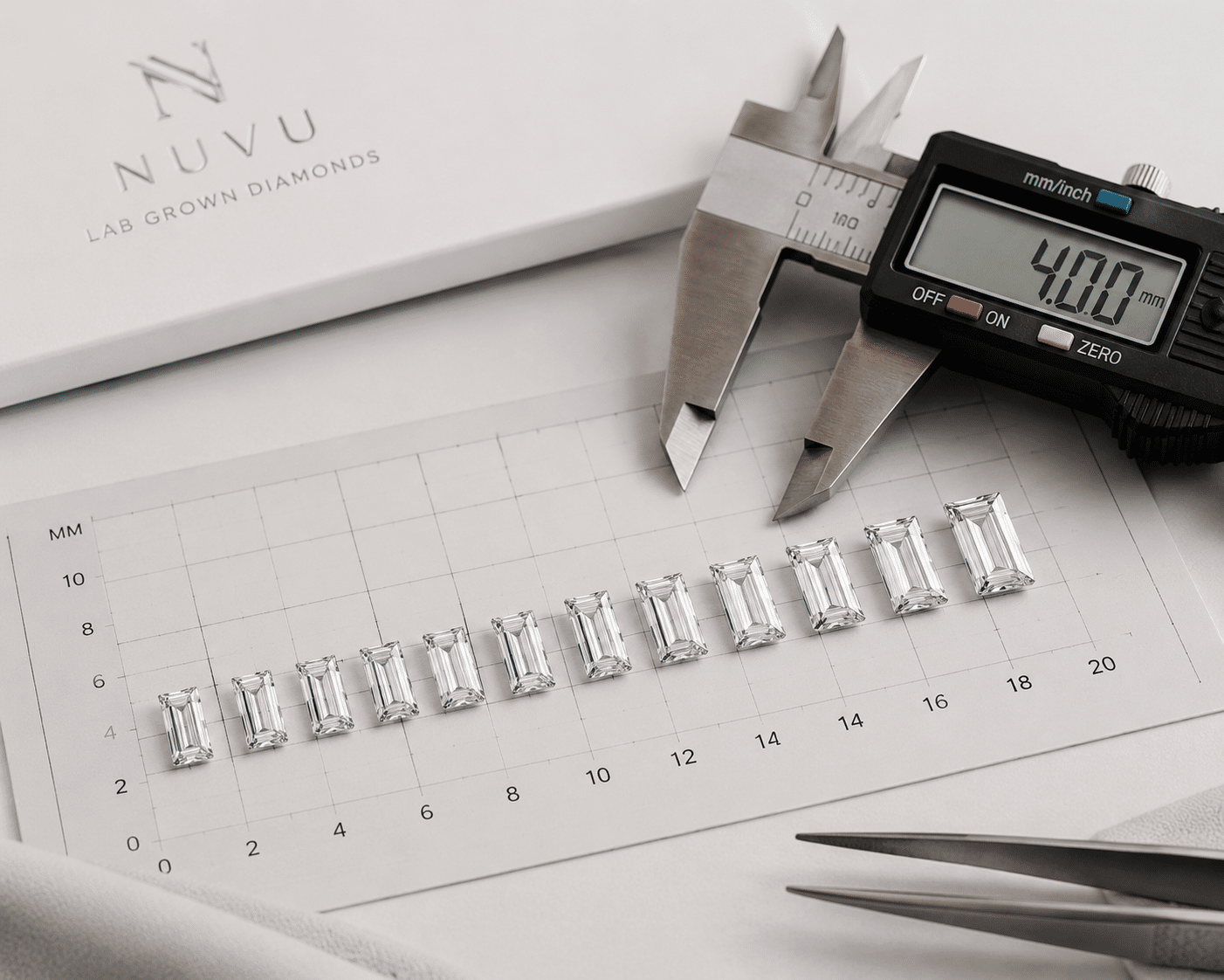 A row of calibrated baguette-cut diamonds laid out on a measurement grid, with a digital caliper visible next to the row for size verification