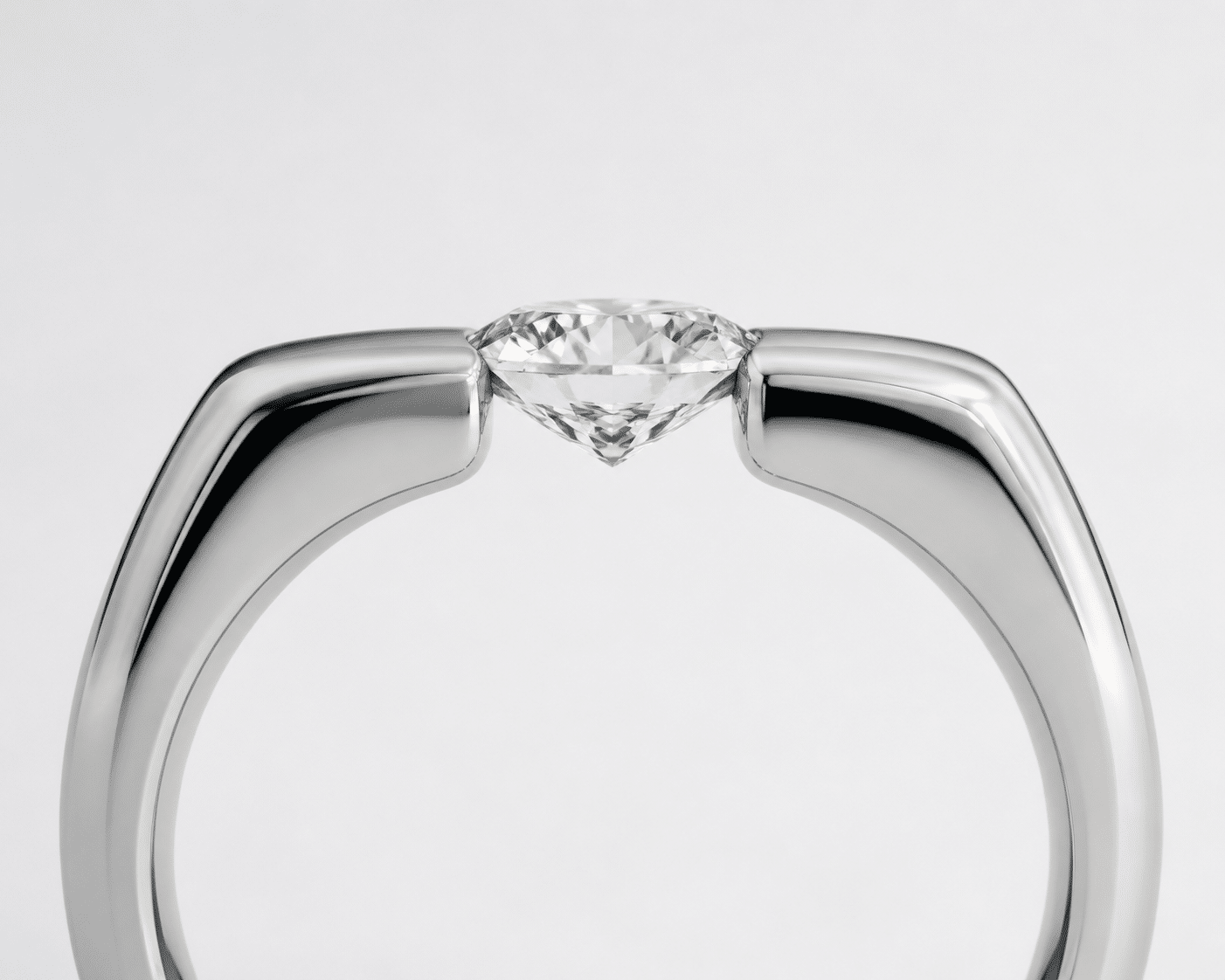 Side view of a tension-set diamond showing the metal band compressing against the girdle with no prongs or bezel