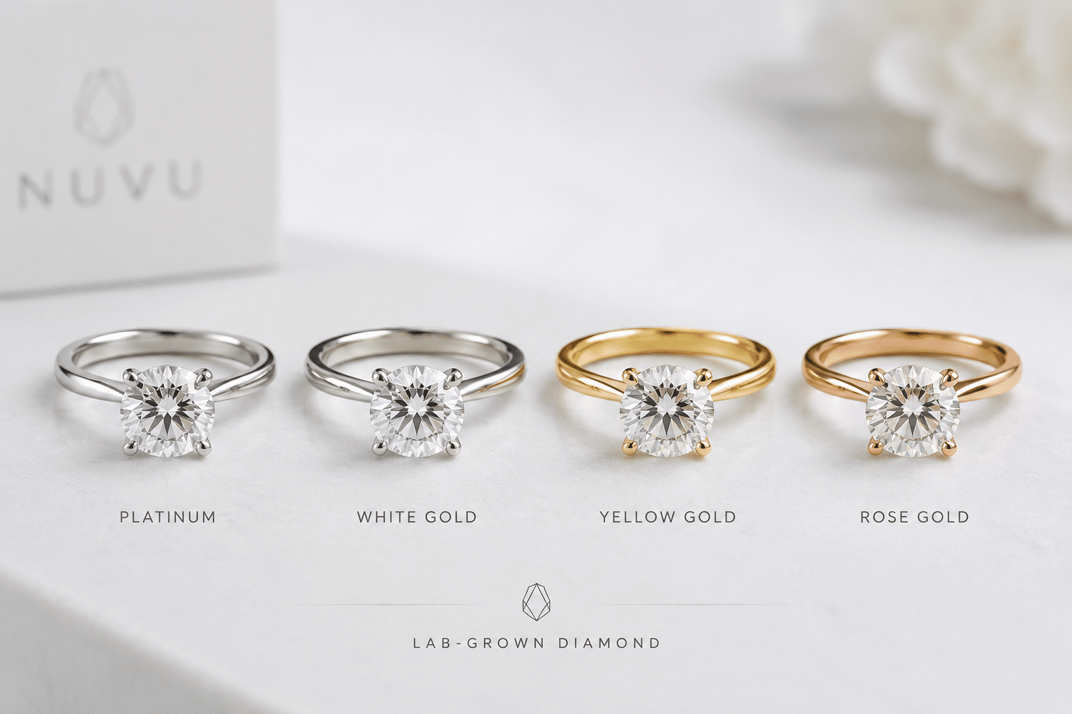 Four engagement rings side by side showing platinum, white gold, yellow gold, and rose gold settings with a near-colorless lab-grown diamond in each